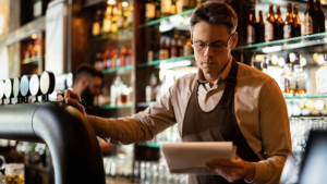 Un barista en train de regarder son permis d'exploitation pour vendre de l'alcool
